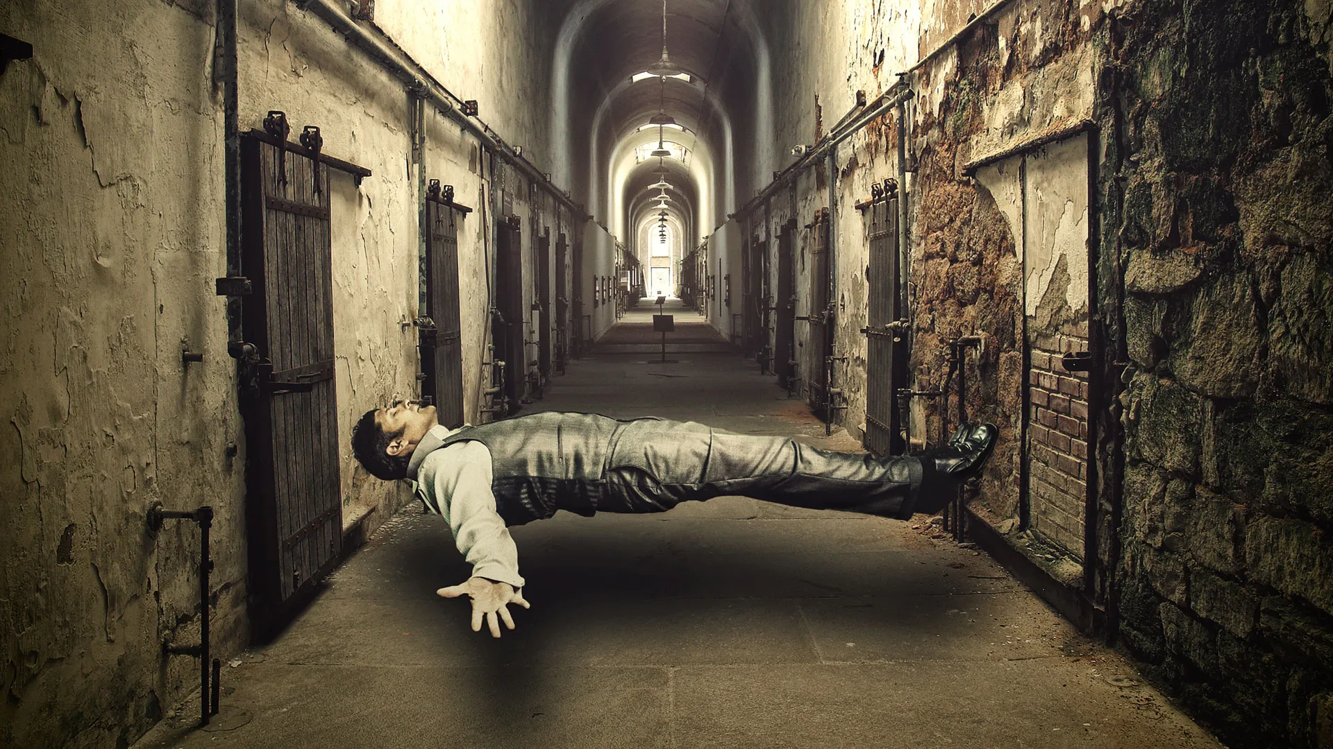 Curt Anderson levitating in abandoned prison corridor